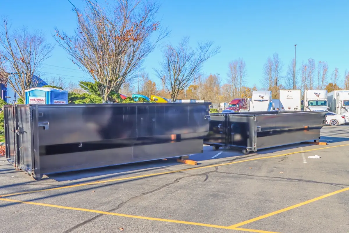 Professional dumpster rental service with roll-off container on residential driveway in East Marlborough